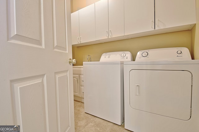 laundry room with cabinets, washer and dryer, and light tile patterned floors