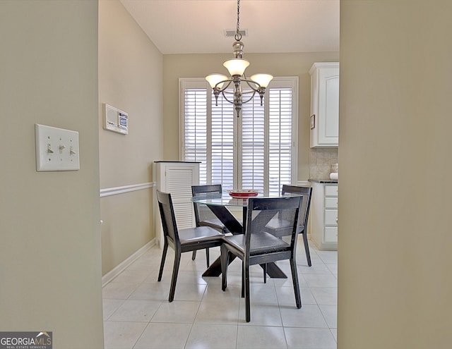 tiled dining space with an inviting chandelier