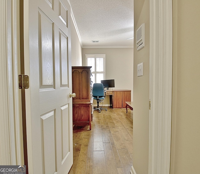 home office featuring crown molding, a textured ceiling, and light wood-type flooring