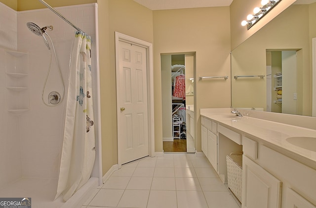 bathroom with tile patterned flooring, vanity, and walk in shower