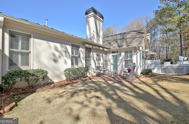 back of property with a yard and a patio area