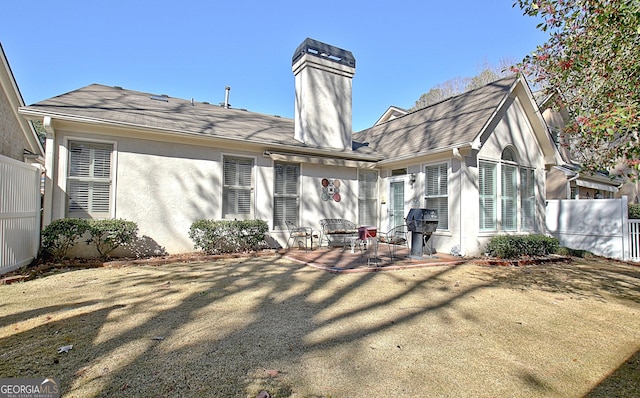 rear view of property with a yard and a patio area