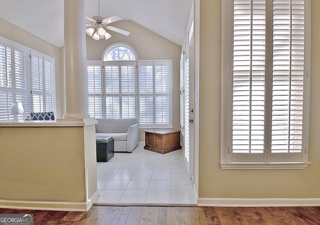 living area featuring ceiling fan, lofted ceiling, light hardwood / wood-style floors, and decorative columns