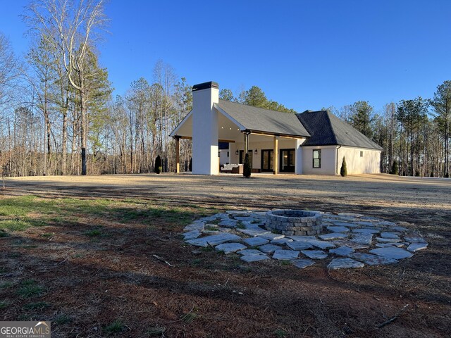 back of house with a fire pit