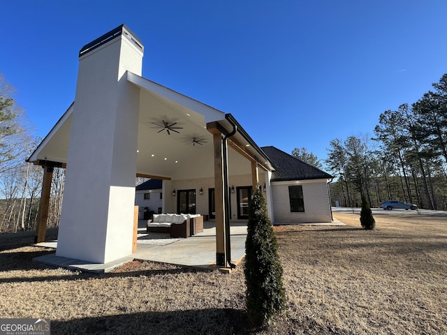 back of property featuring ceiling fan, an outdoor hangout area, and a patio area