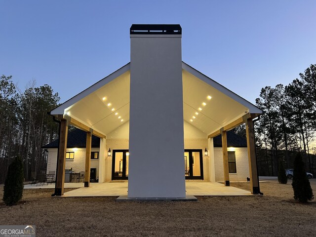 back house at dusk with a patio