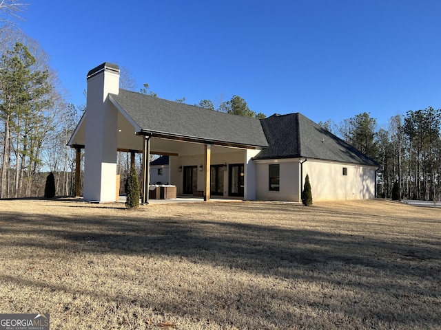 rear view of house featuring a yard and a patio