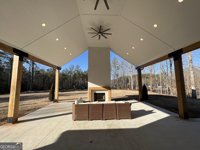 view of patio with ceiling fan and an outdoor living space with a fireplace