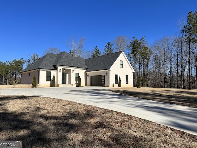 view of side of property with a shingled roof, concrete driveway, and an attached garage