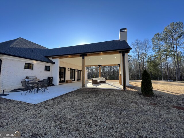 rear view of property featuring an outdoor hangout area and a patio