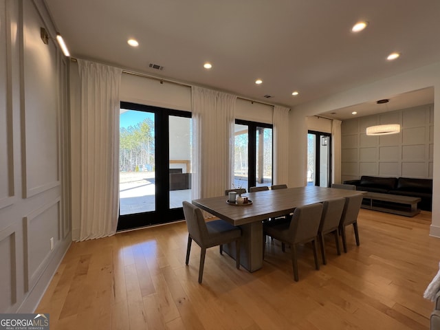 dining area with french doors and light hardwood / wood-style floors