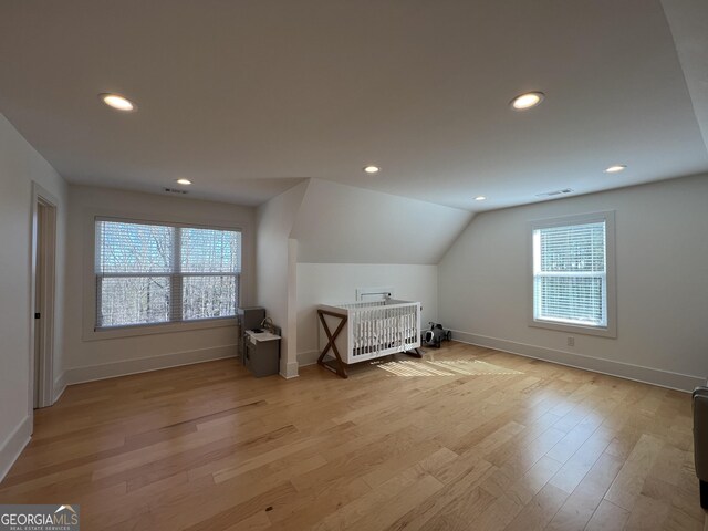 bonus room featuring light wood-type flooring and vaulted ceiling