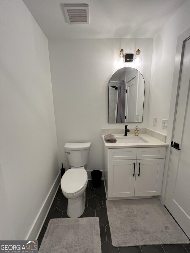 bathroom with tile patterned floors, toilet, and vanity