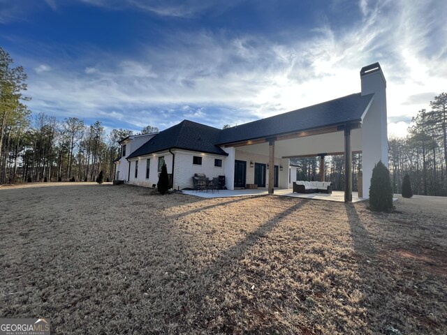 rear view of house featuring an outdoor living space and a patio