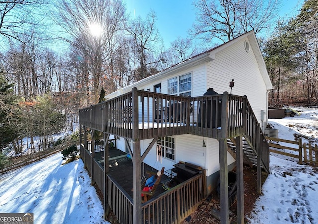 snow covered house with a deck