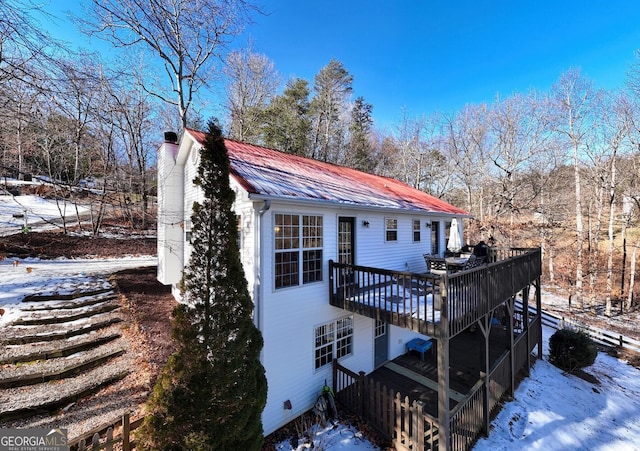 snow covered property with a wooden deck