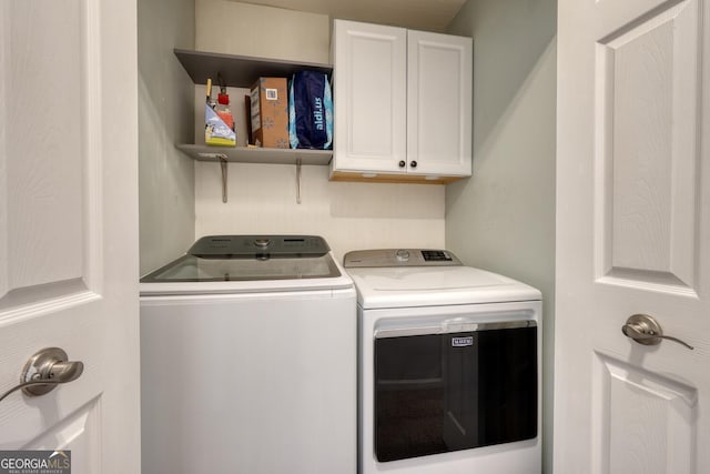 clothes washing area featuring independent washer and dryer and cabinets