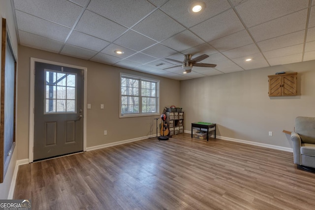 foyer entrance with a drop ceiling, a wealth of natural light, wood-type flooring, and ceiling fan