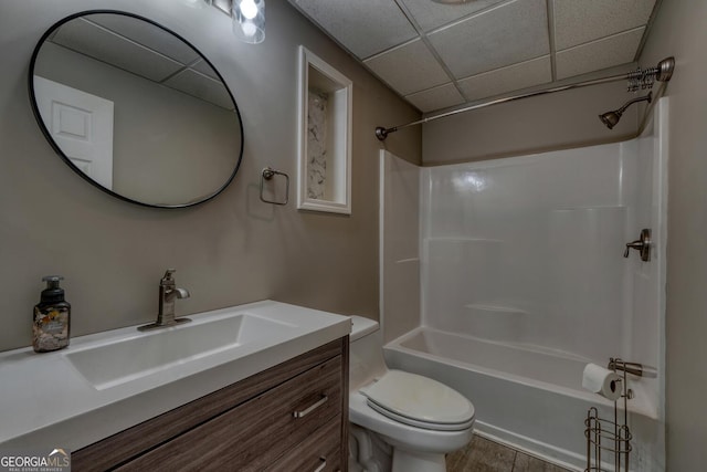 full bathroom featuring a drop ceiling, vanity, toilet, and washtub / shower combination