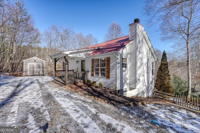 single story home featuring covered porch and a storage shed