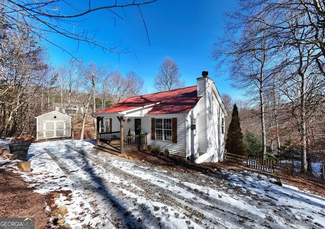 view of front of property with a porch and a shed