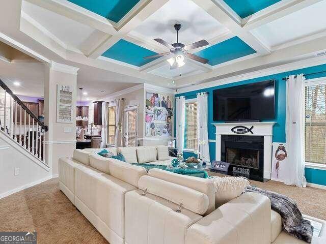 carpeted living room with beam ceiling, coffered ceiling, and ornamental molding