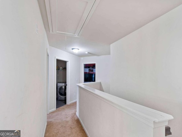 hallway featuring washer / dryer and light carpet