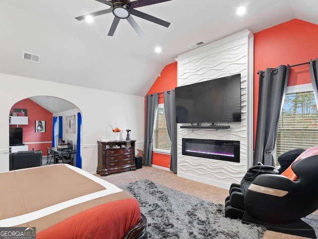 carpeted bedroom featuring ceiling fan, a large fireplace, and vaulted ceiling