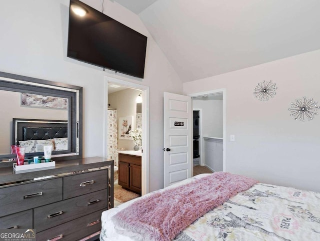 bedroom featuring vaulted ceiling and connected bathroom