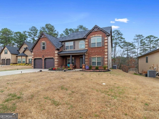 view of front of property with a garage, a front lawn, and central AC