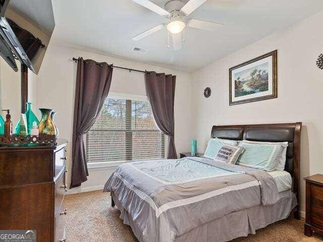 bedroom with ceiling fan and light carpet