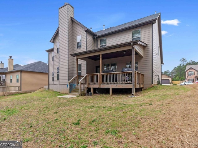 rear view of property featuring a lawn and a wooden deck