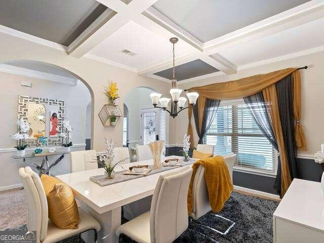 carpeted dining space with an inviting chandelier, crown molding, coffered ceiling, and beamed ceiling