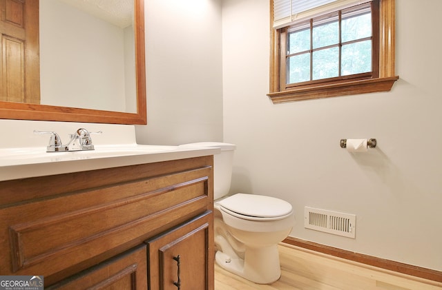 bathroom with hardwood / wood-style floors, toilet, and vanity