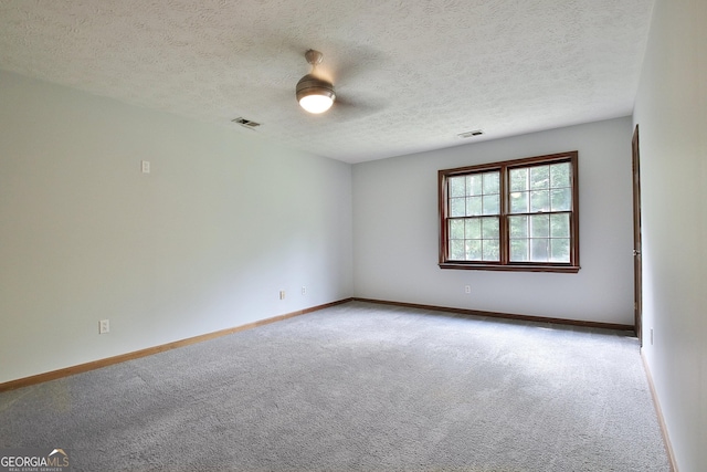 spare room with a textured ceiling and carpet flooring