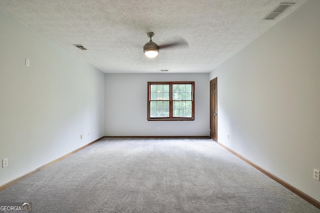 spare room with ceiling fan, carpet, and a textured ceiling