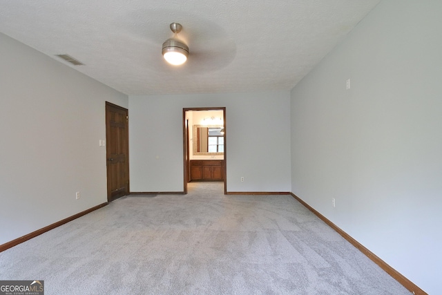 carpeted empty room with ceiling fan and a textured ceiling