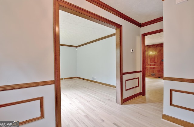 spare room featuring light hardwood / wood-style flooring and ornamental molding