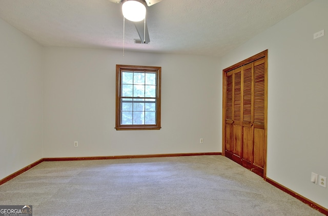 unfurnished bedroom with a textured ceiling and carpet flooring