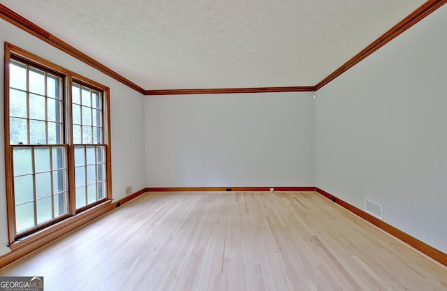 spare room featuring crown molding, a textured ceiling, and light hardwood / wood-style floors