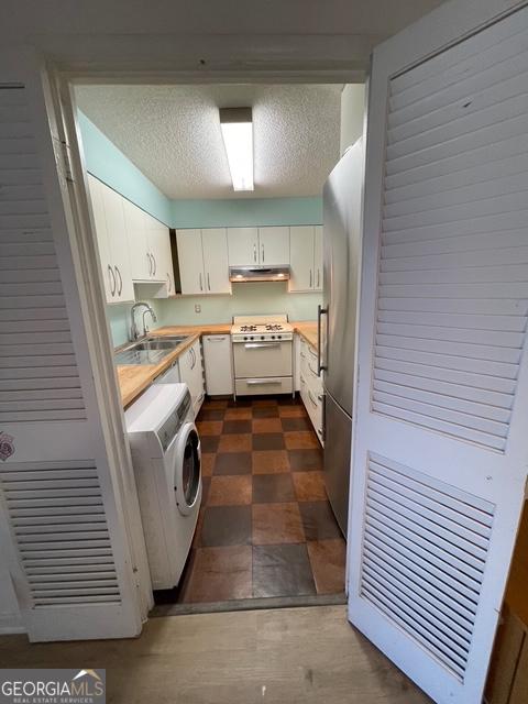 laundry room with washer / clothes dryer, sink, and a textured ceiling