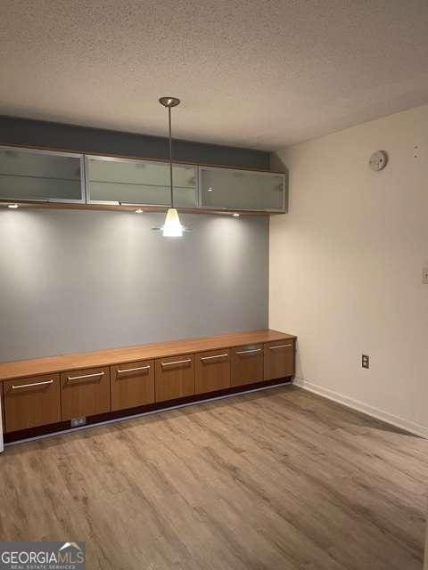 interior space with a textured ceiling and hardwood / wood-style flooring