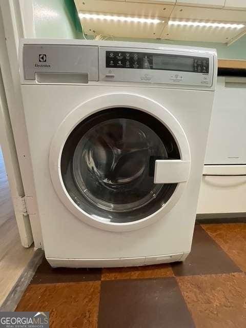 laundry room with dark tile patterned flooring and washer / clothes dryer