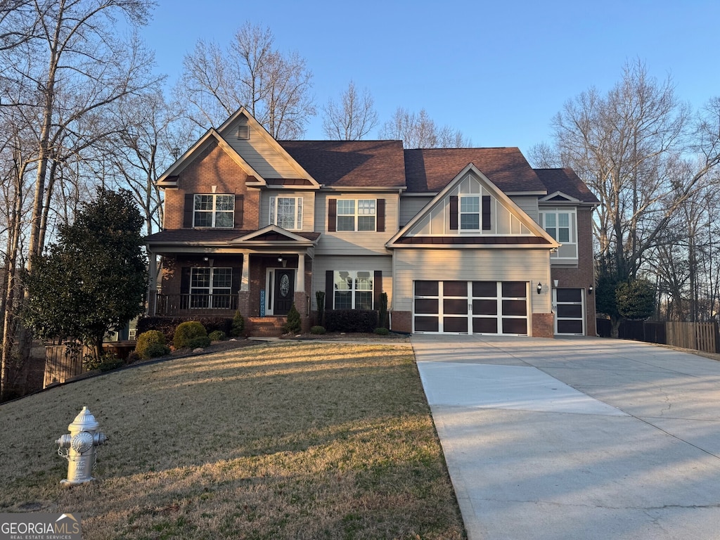 craftsman inspired home with a garage, a front yard, and covered porch