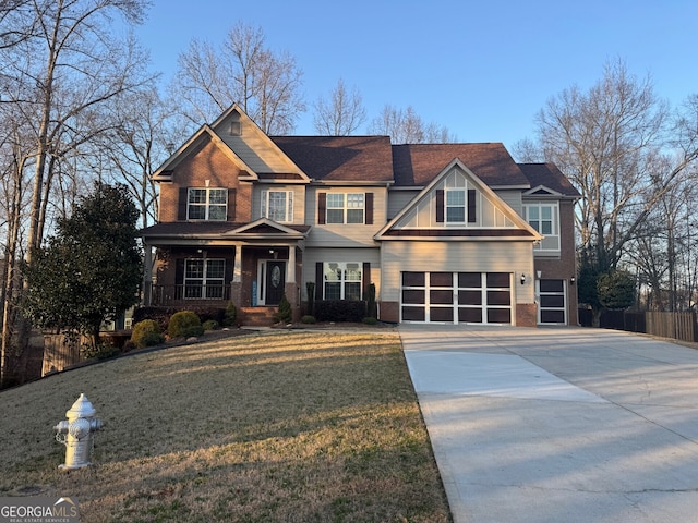 craftsman inspired home with a garage, a front yard, and covered porch