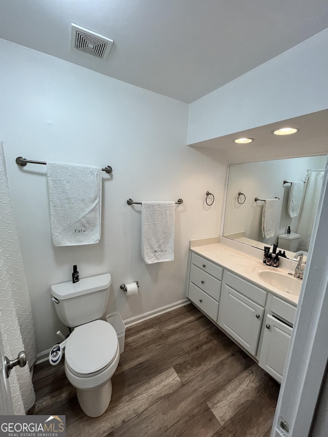 bathroom with hardwood / wood-style floors, toilet, and vanity