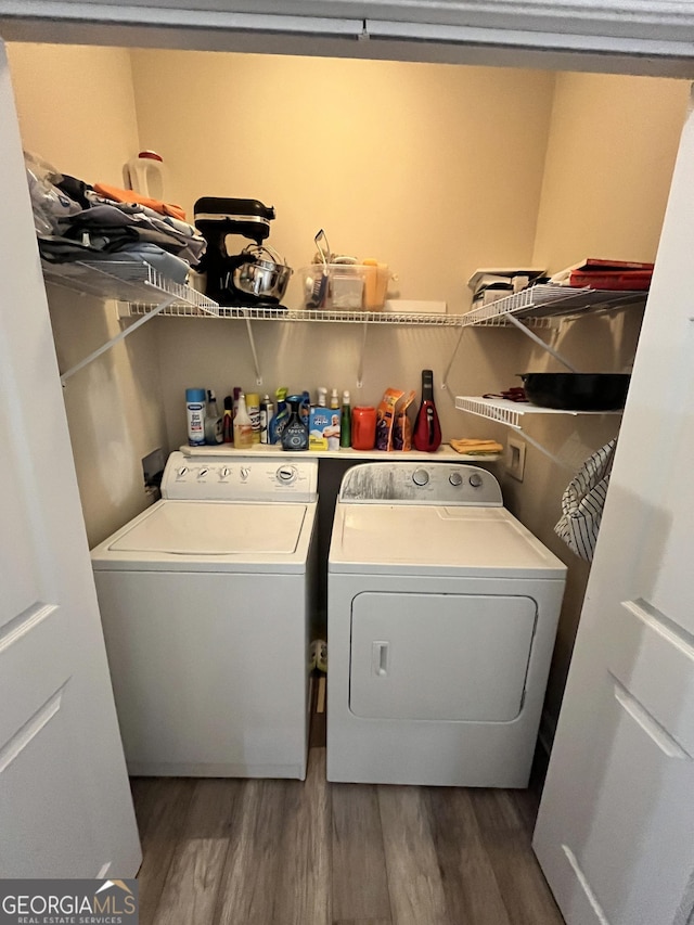 clothes washing area featuring washer and dryer and dark wood-type flooring