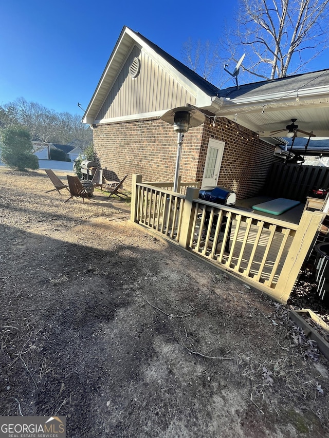 view of home's exterior with a wooden deck and ceiling fan