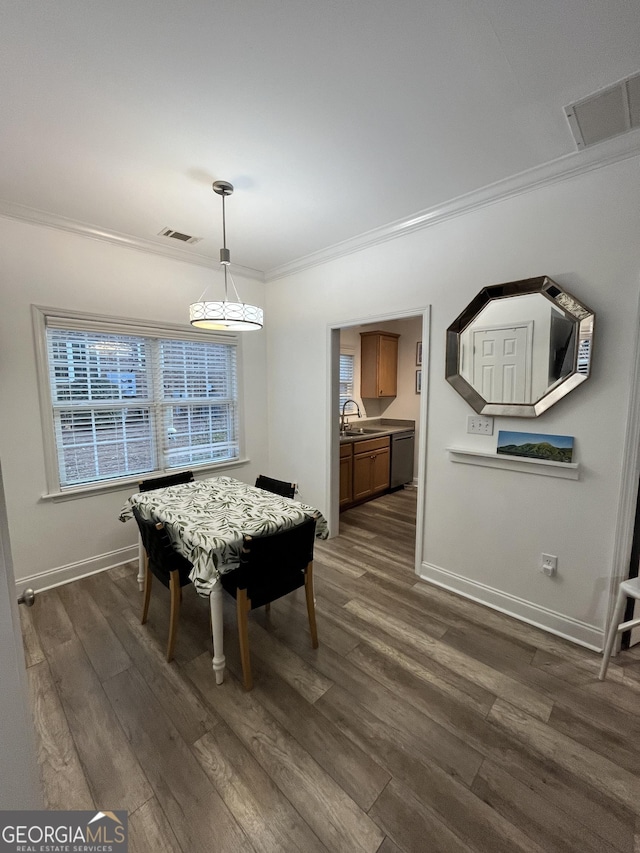 dining area featuring sink, dark hardwood / wood-style flooring, and crown molding