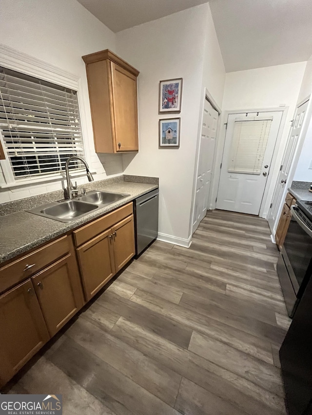 kitchen with sink, appliances with stainless steel finishes, and dark hardwood / wood-style flooring